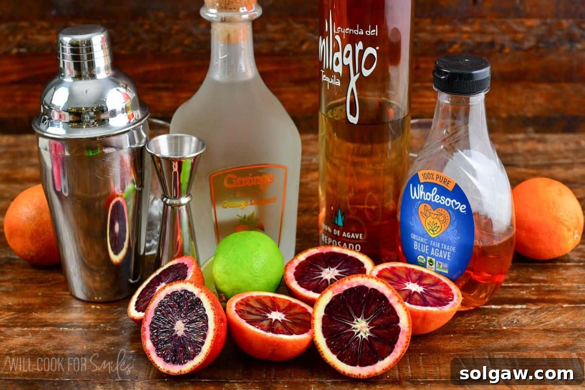 Ingredients for blood orange margaritas on a wood surface.