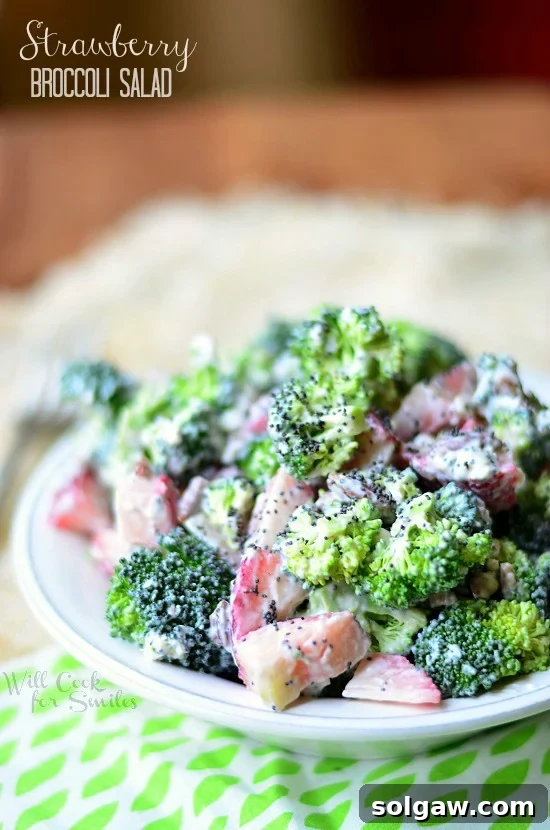 Strawberry Broccoli Salad in a white bowl with a green and white placemat