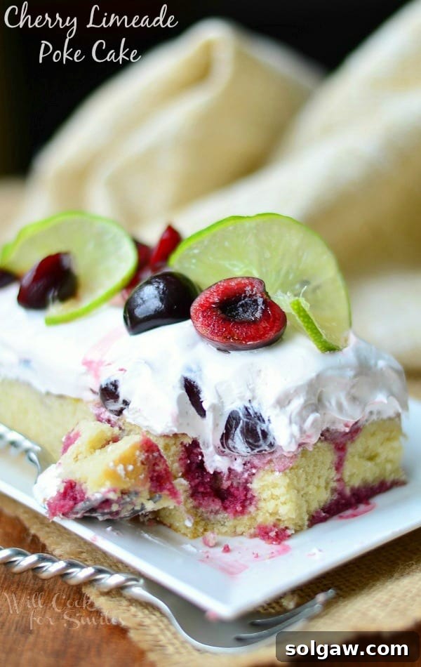 Cherry Limeade Poke Cake on a white plate with a fork