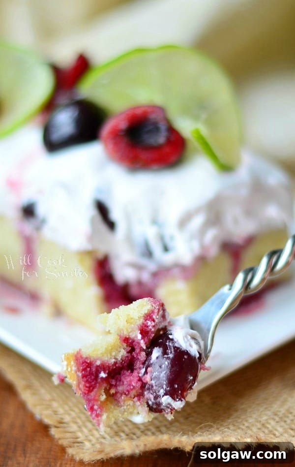 Cherry Limeade Poke Cake on a plate with a bite on a fork