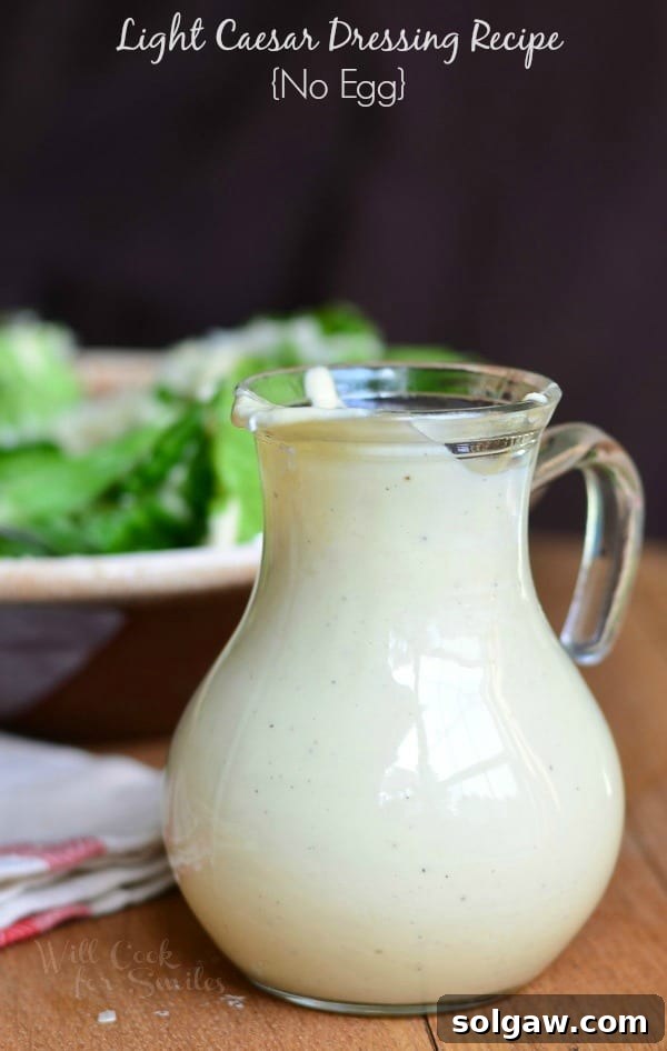 Close-up of a glass cruet filled with golden light Caesar dressing, positioned next to a bowl of fresh greens and croutons, ready to enhance a meal.