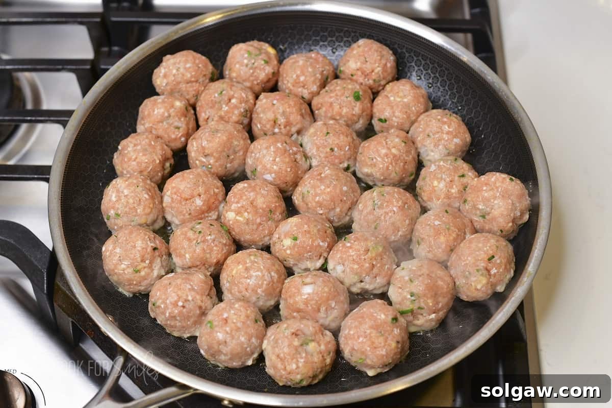 meatballs in the cooking pan starting to cook.