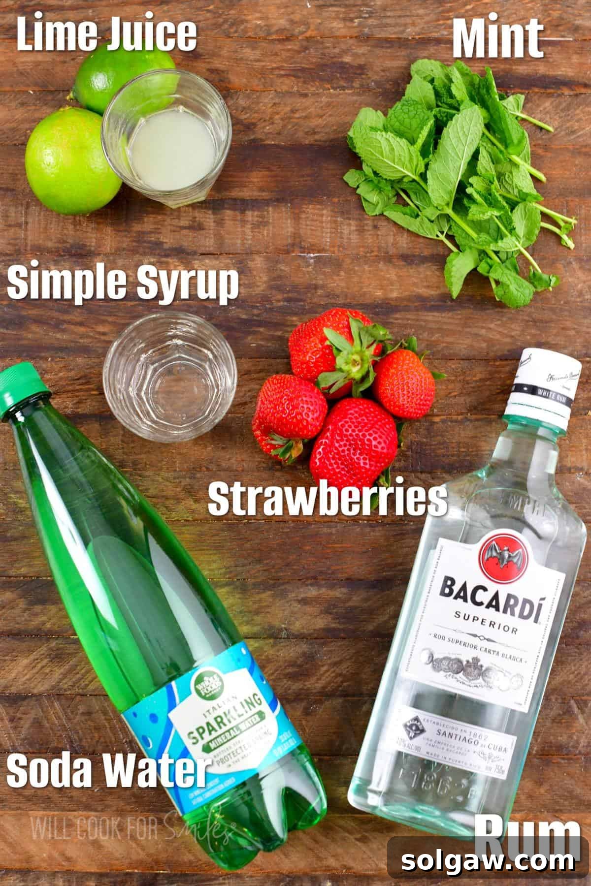 The ingredients for strawberry mojito are placed on a wooden surface. 