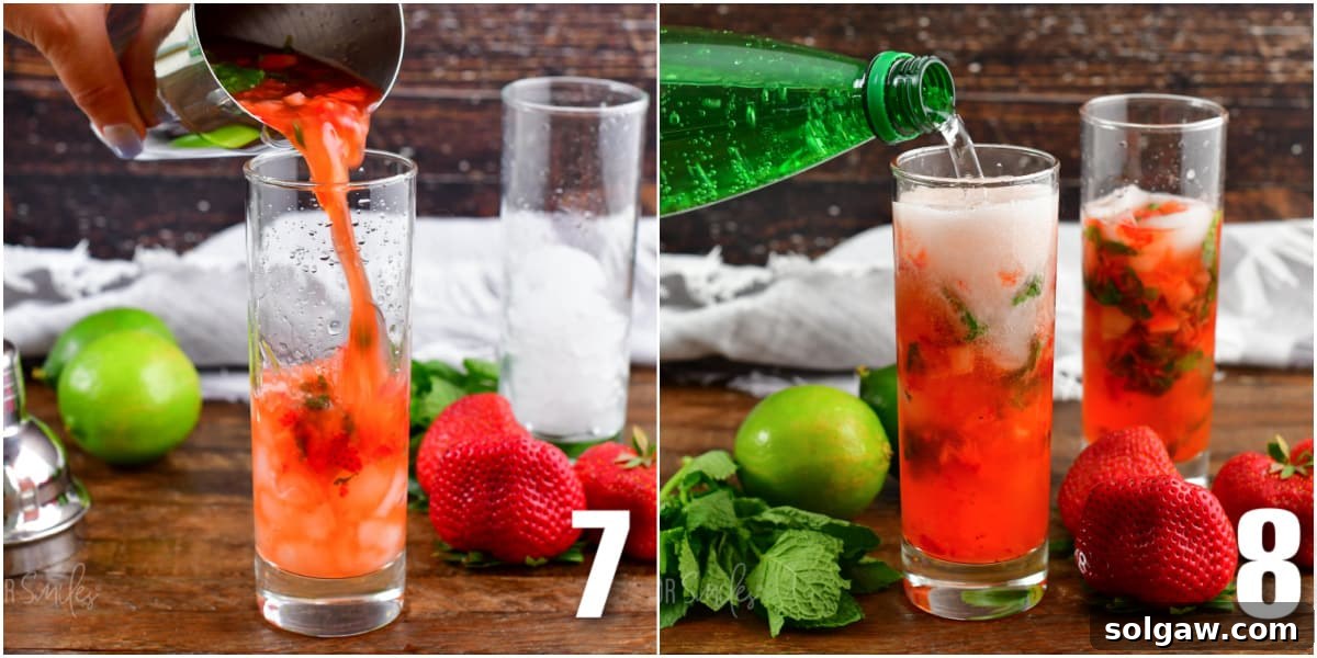 Hand muddling strawberries and mint leaves in a cocktail shaker.