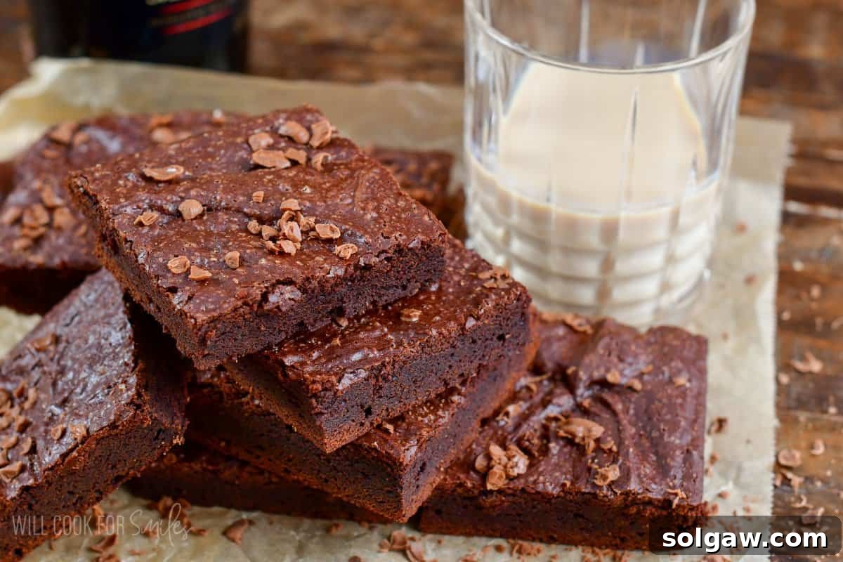 brownies fanned out on parchment paper with a glass of baileys to the side.