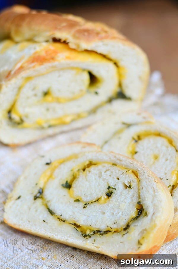 Two fresh baked loaves of Cheddar Herb Swirl Bread cooling on a wire rack, steam gently rising.
