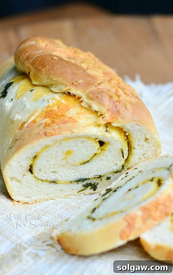 A close-up view of the golden-brown crust of the Cheddar Herb Swirl Bread, with visible hints of cheese and herbs.