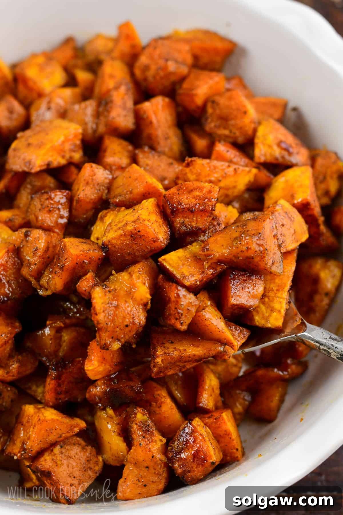 Spiced roasted honeynut squash in a bowl with a spoon scooping some out.