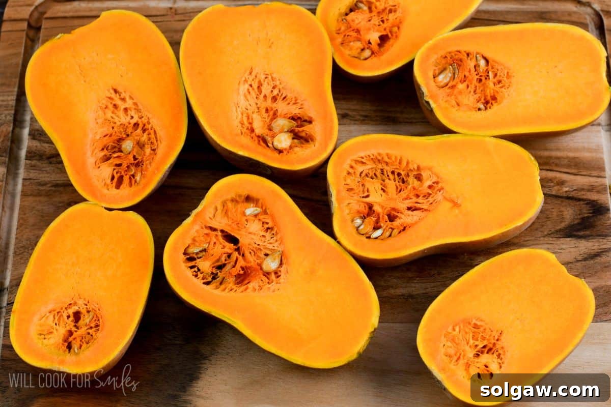 honeynut squash cut in half on a wood surface.