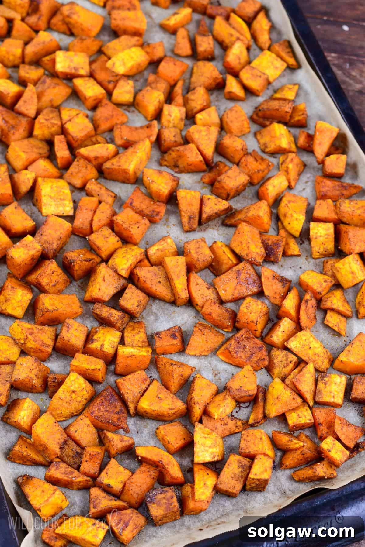 Honeynut squash spread on a parechment paper lined baking sheet.