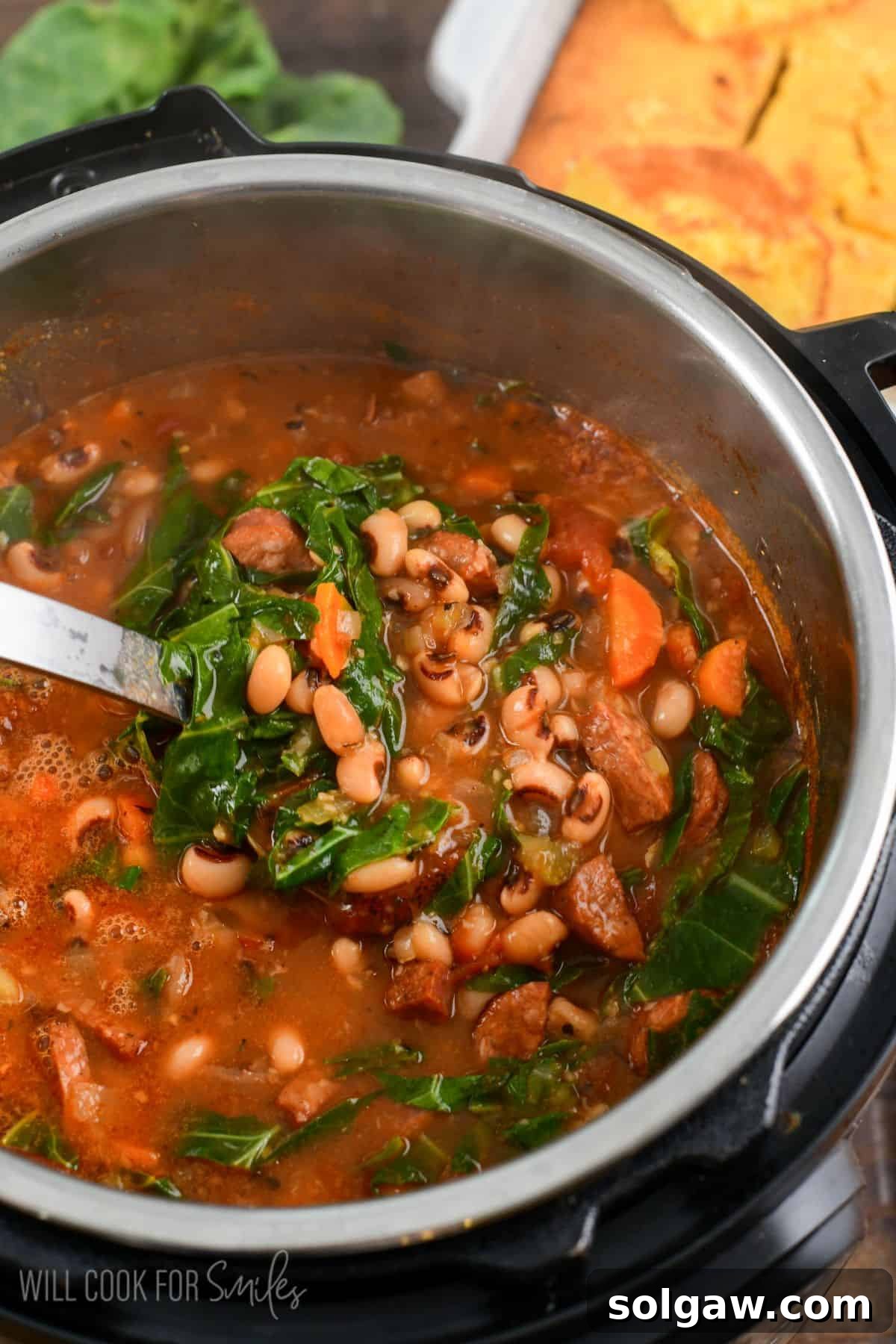 A large serving spoon scooping out a generous portion of hearty Southern black-eyed pea soup with smoky sausage and tender collard greens directly from the Instant Pot, ready to be served with cornbread.
