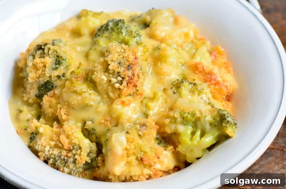 A light bowl filled with a generous serving of cheesy broccoli cheese casserole, ready to be enjoyed as a comforting side dish.