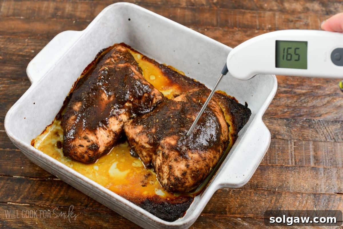taking temperature of the tender baked turkey tenderloin in a balsamic glaze in a baking dish.