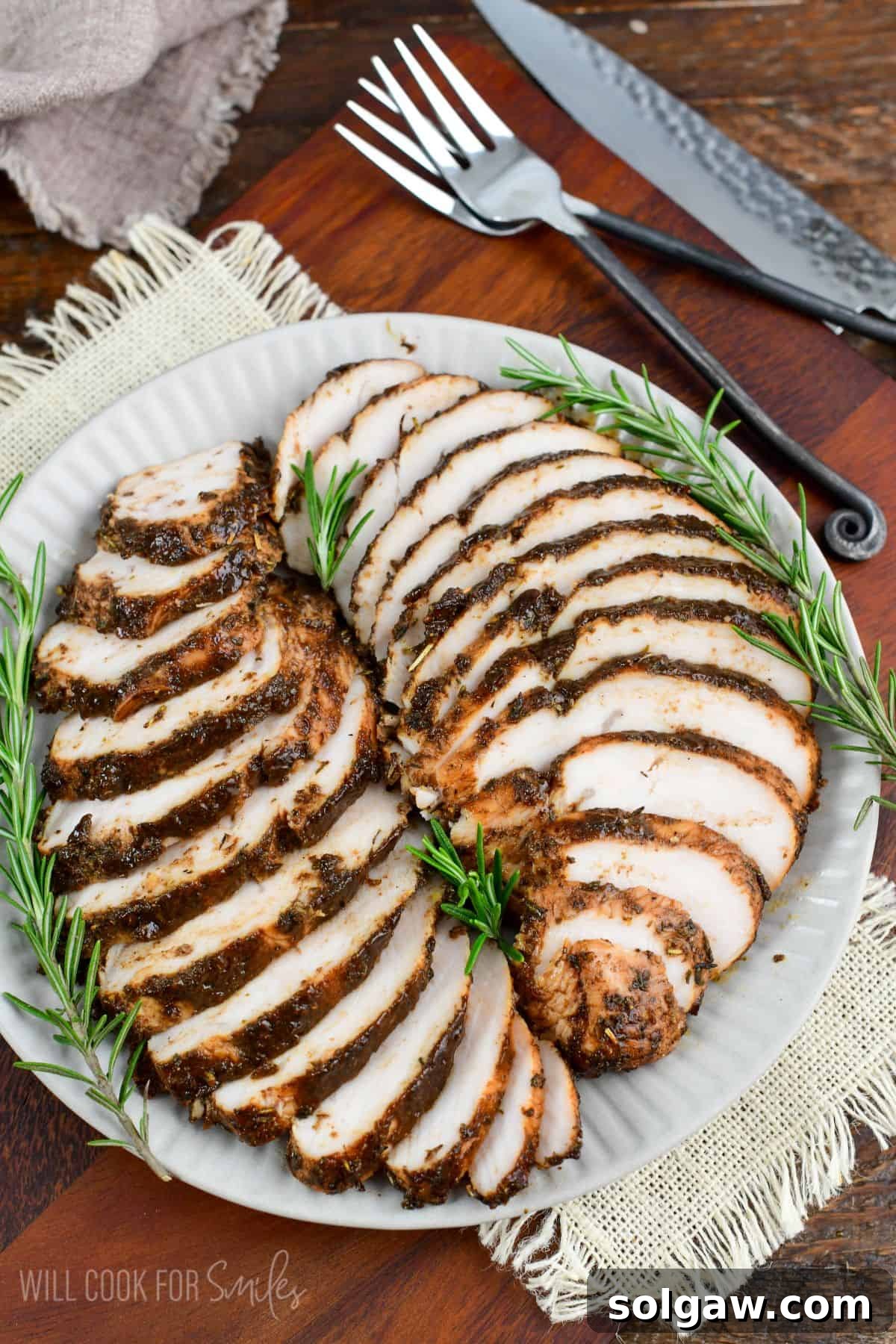 two sliced baked turkey tenderloins in a balsamic mixture layered on the plate.
