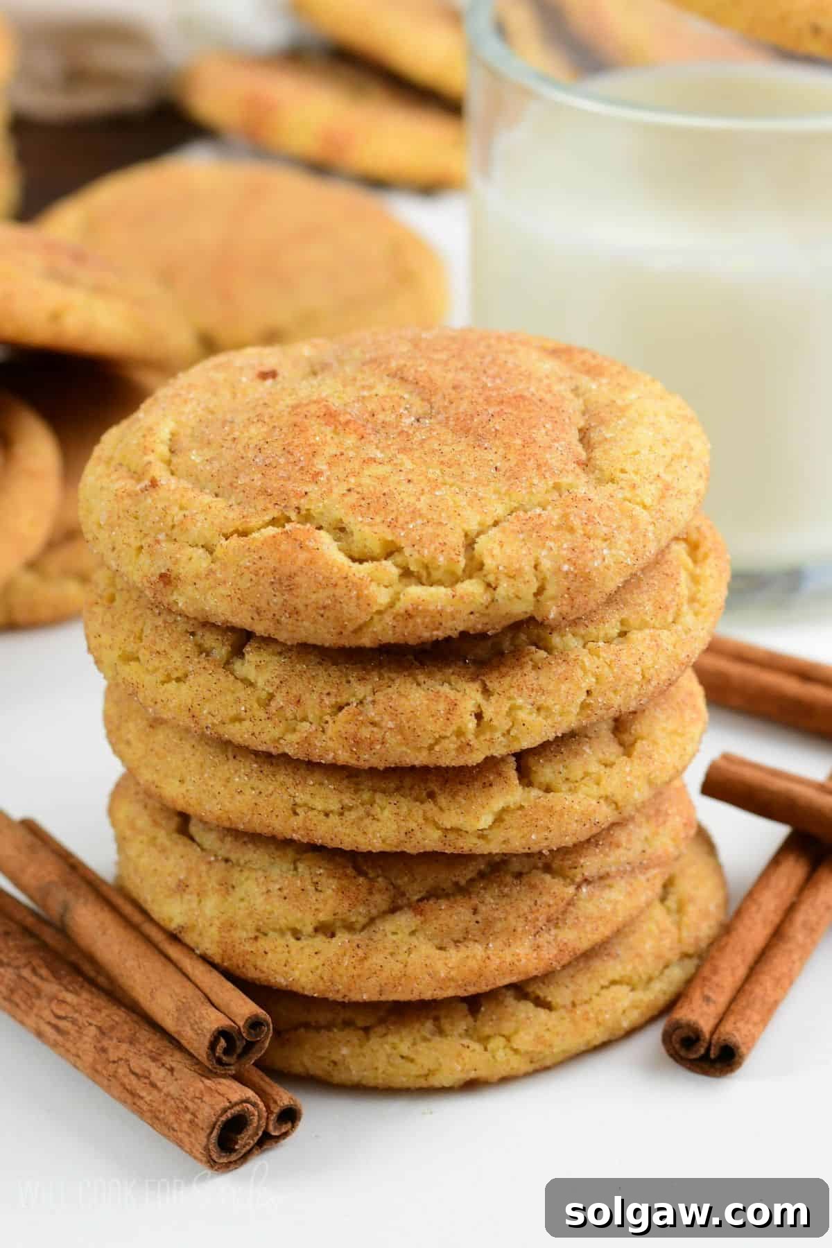 soft and chewy snickerdoodle cookies made with brown butter stacked next to glass of milk.