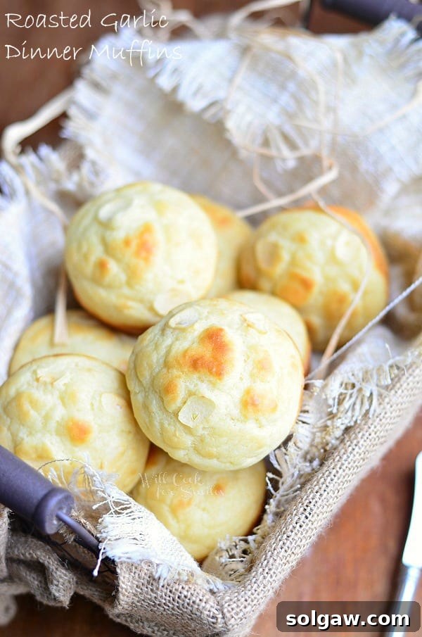Golden brown roasted garlic dinner muffins in a basket, viewed from above, highlighting their soft texture.