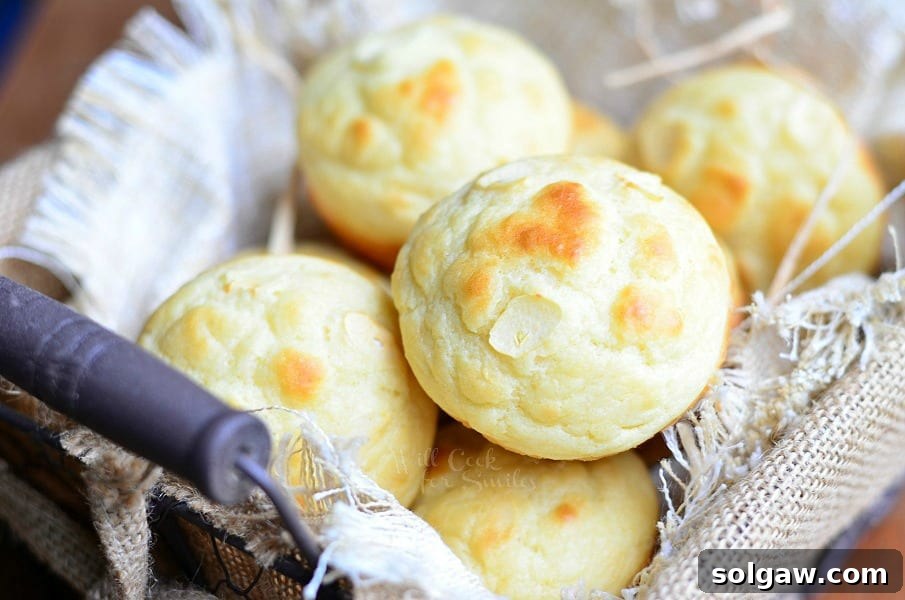 Close-up of baked roasted garlic dinner muffins on a cooling rack, showcasing their golden crust and fluffy interior.