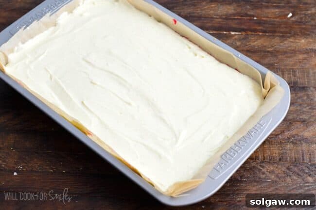 The unbaked Christmas Cheesecake Bars, beautifully layered and ready for the oven, resting on a wooden surface, promising a delicious holiday treat.
