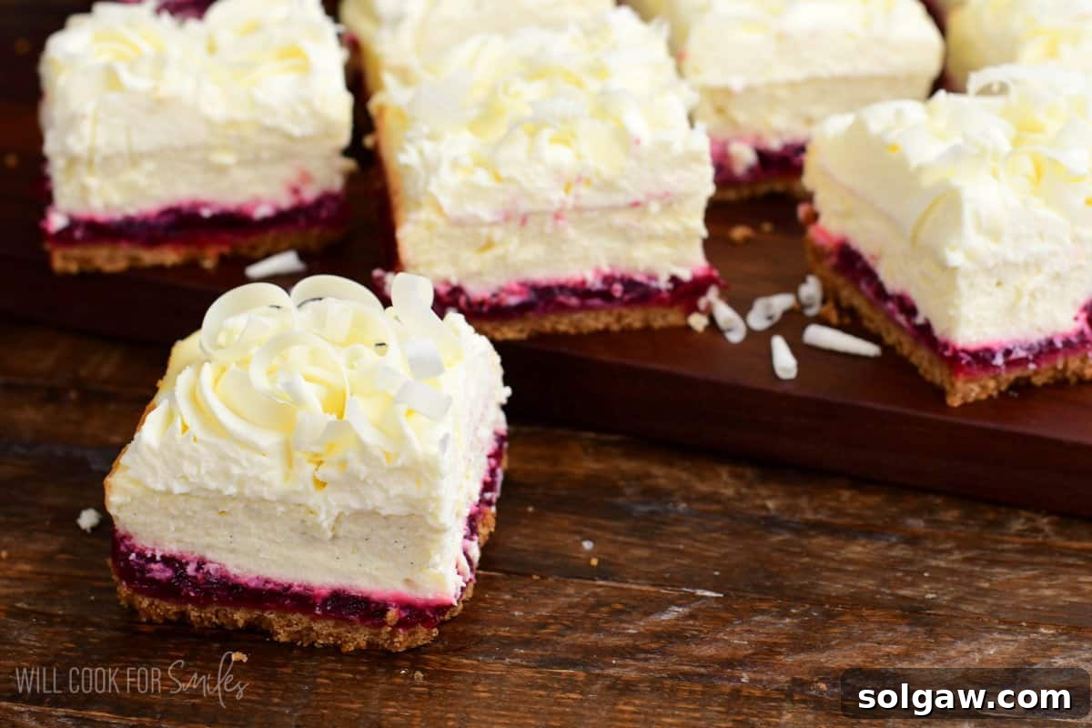 A beautifully composed image featuring one slice of Christmas Cheesecake Bars, garnished with white chocolate shavings, resting on a serving board next to the remaining uncut bars.
