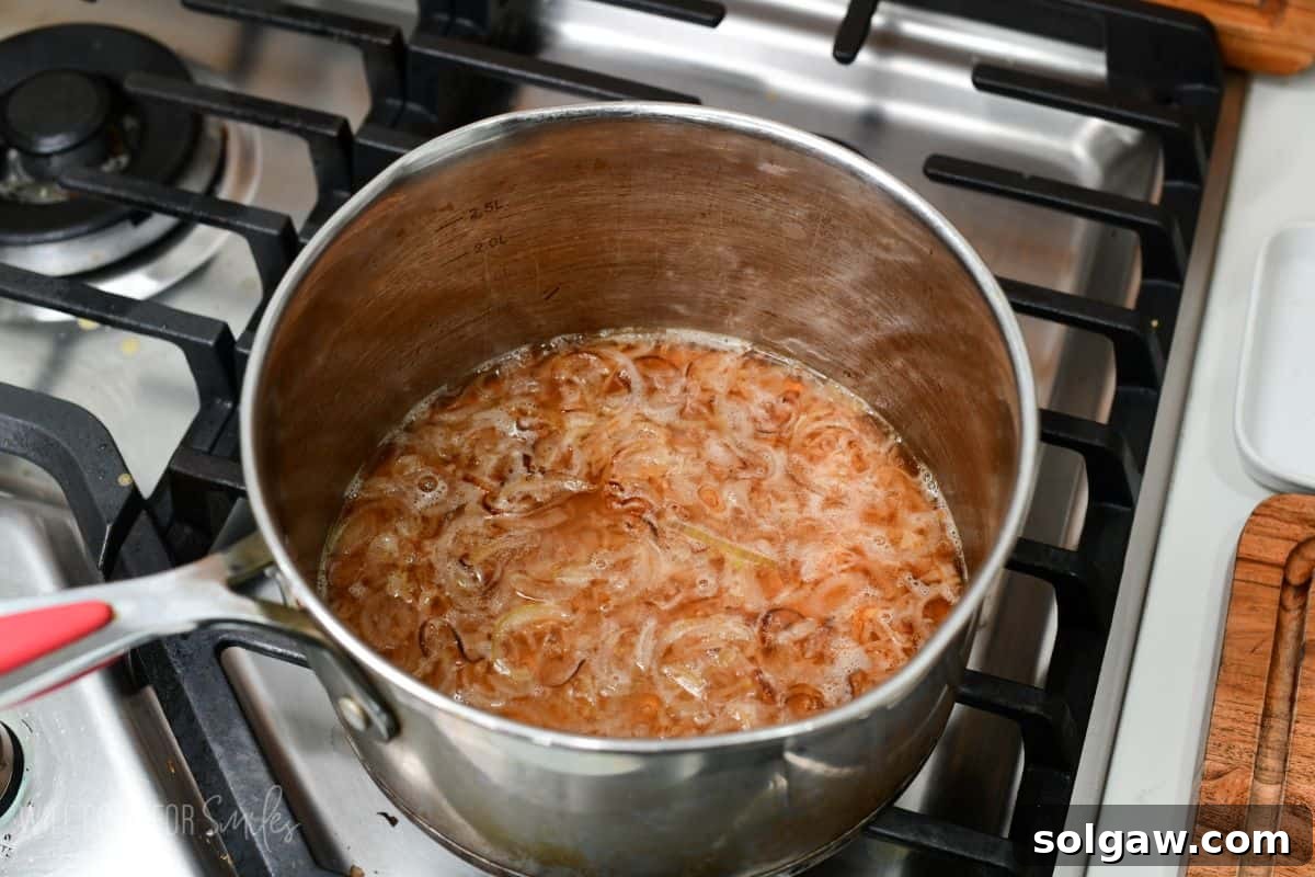 simmering white wine with sauteed shallots in a large silver pot.