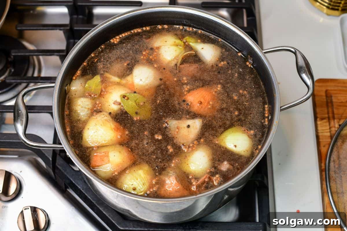 vegetables, beef, been bones, and seasoning all combined with water in a soup pot.