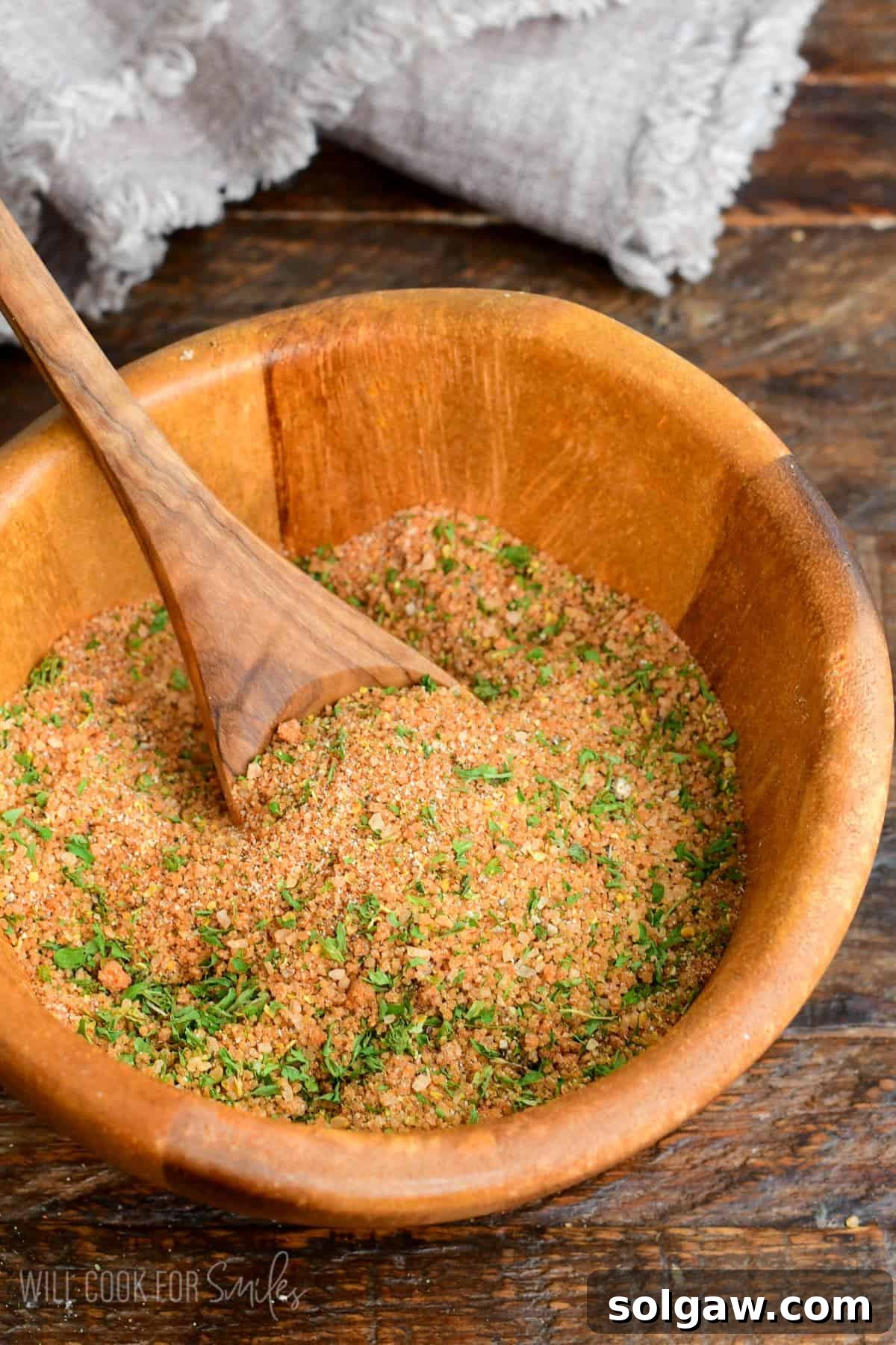 pork rub seasoning in a wooden bowl with a wooden spoon in it.