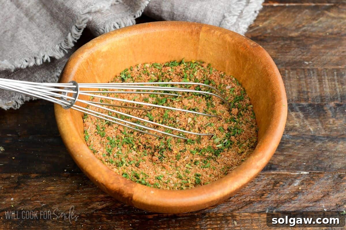 mixing pork rub with a whisk in a wooden bowl.