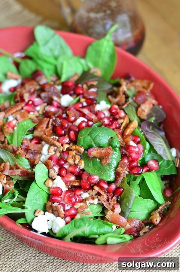 Vibrant Spinach Salad with Pomegranate, Goat Cheese, Pecans, and Bacon, dressed with Homemade Pomegranate Vinaigrette