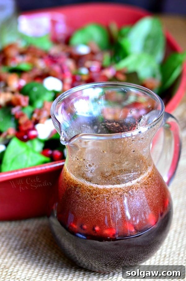 Freshly prepared Homemade Pomegranate Vinaigrette in a glass jar, ready to dress a delicious salad
