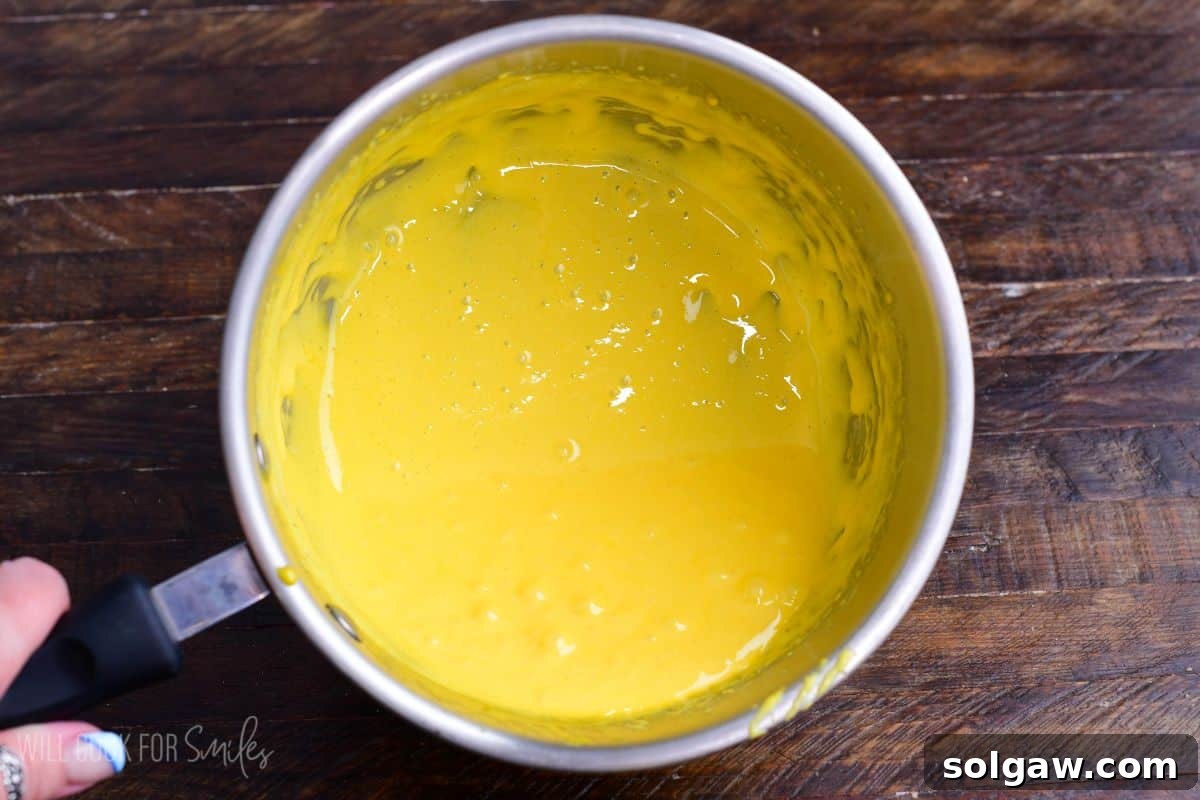 Velvet Pistachio Tiramisu 7 Cooked egg yolk custard mixture in a saucepan, thickened and smooth after whisking.