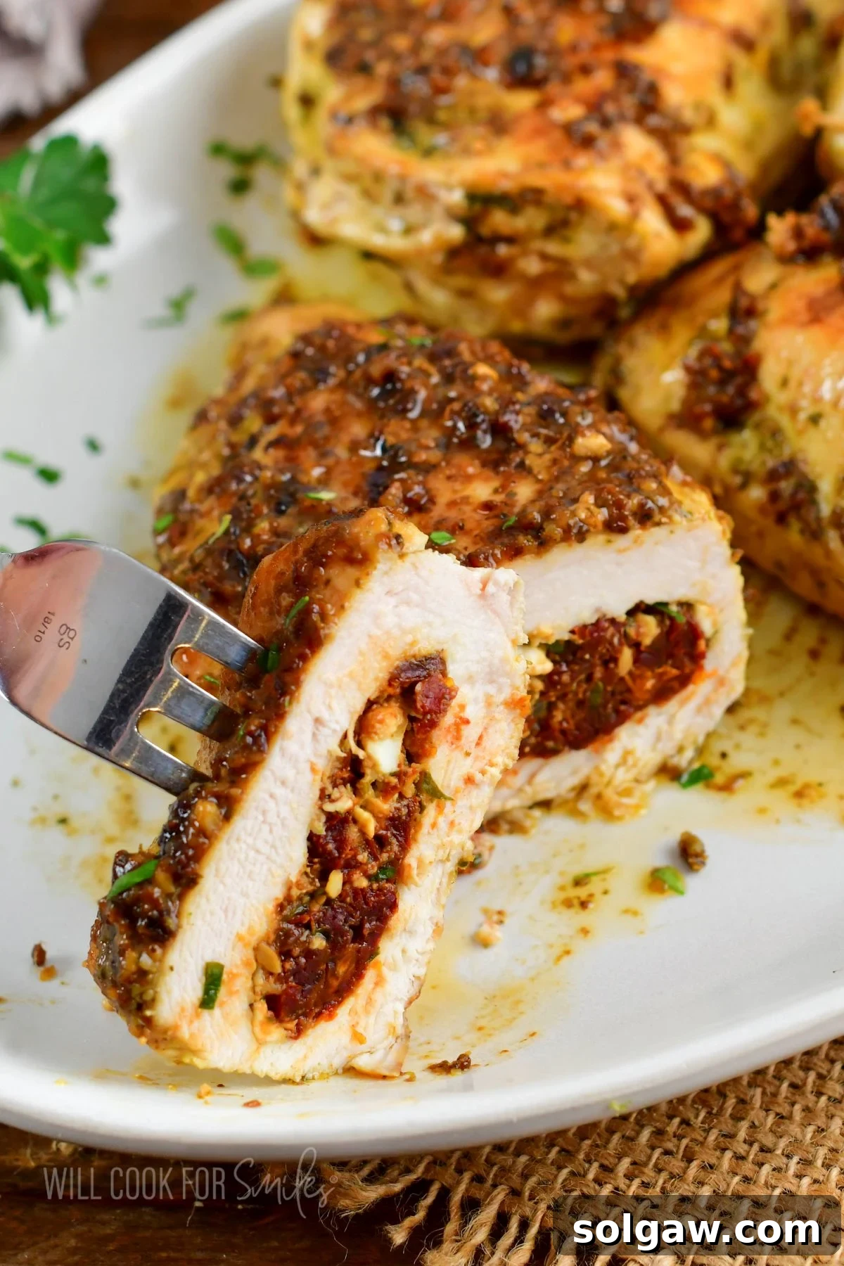 Feta Sun-Kissed Chicken 2 cutting into a perfectly cooked stuffed chicken breast revealing the sun-dried tomato and feta filling.