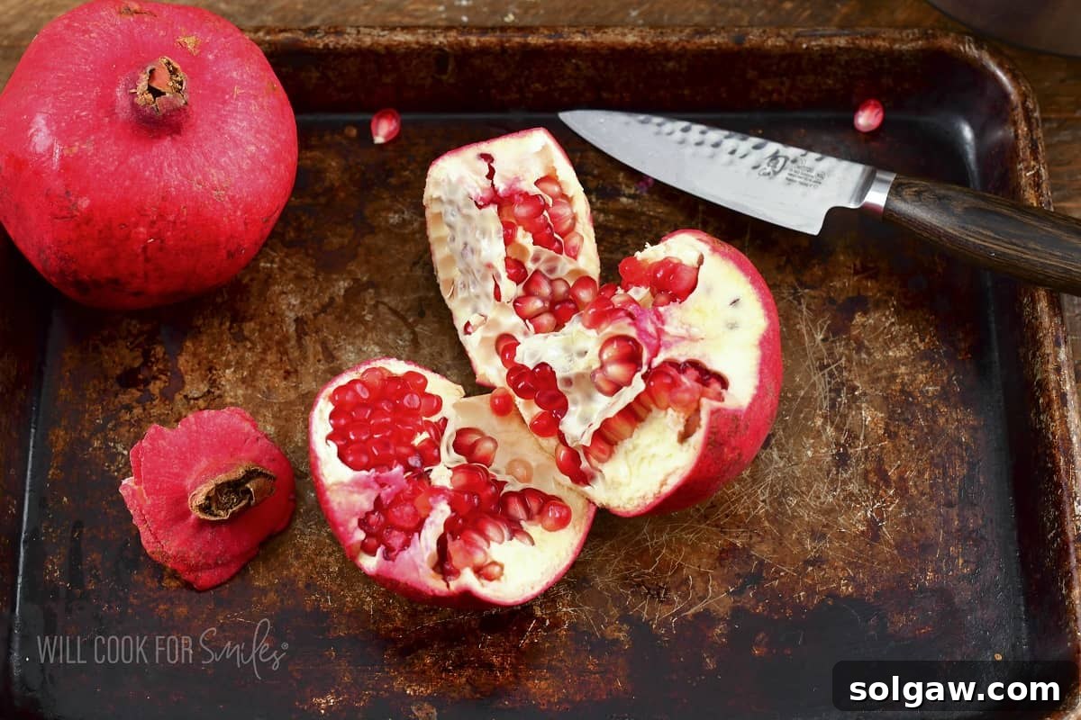 Pomegranate cut into several distinct pieces, ready for seed separation.