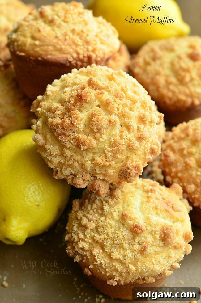 Close-up of freshly baked Lemon Streusel Muffins with a crumbly topping, stacked on a cooling rack.