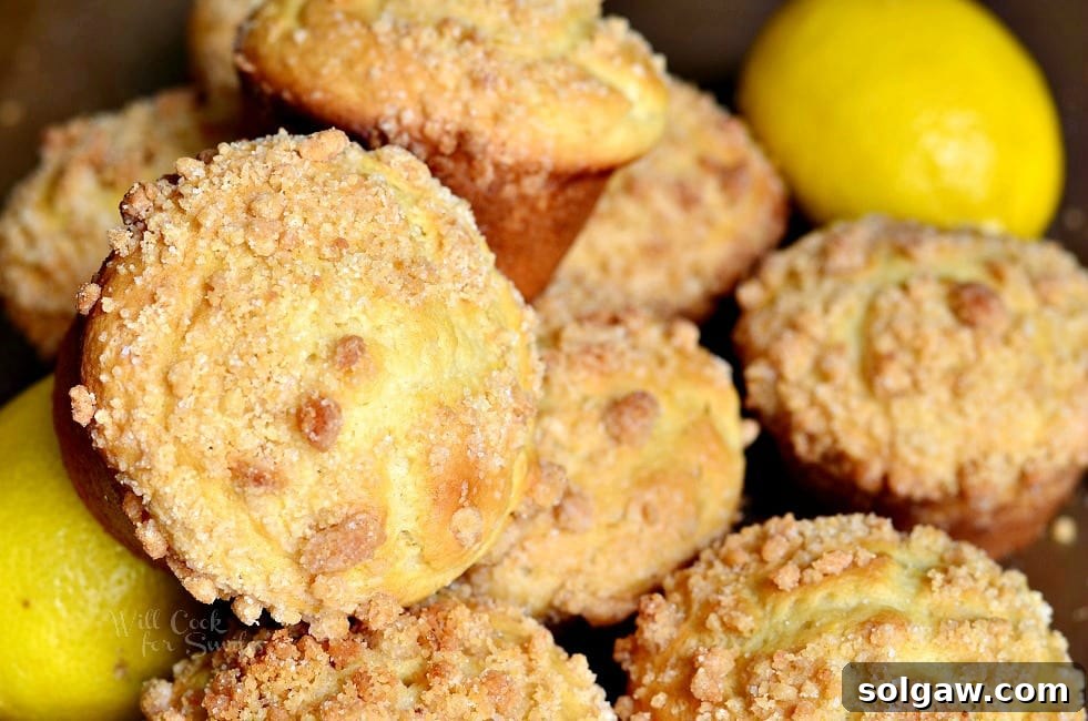 Two Lemon Streusel Muffins split open, showcasing their soft interior and citrus zest.