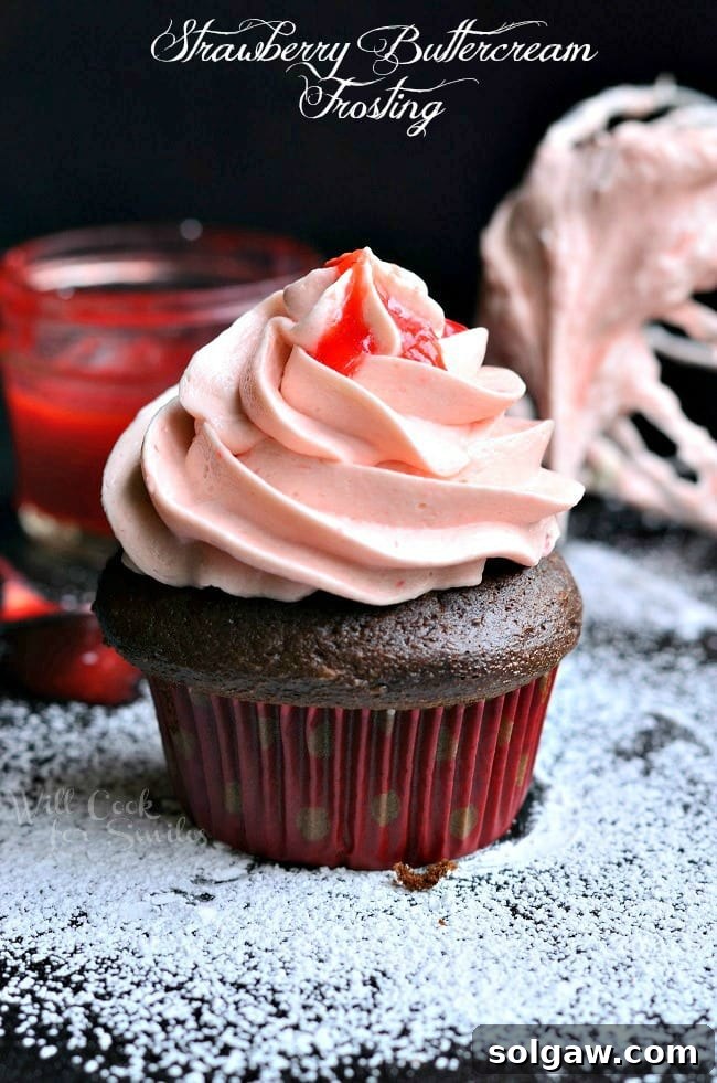 Strawberry Buttercream Frosting on a chocolate cupcake, dusted with powdered sugar, ready to be served.