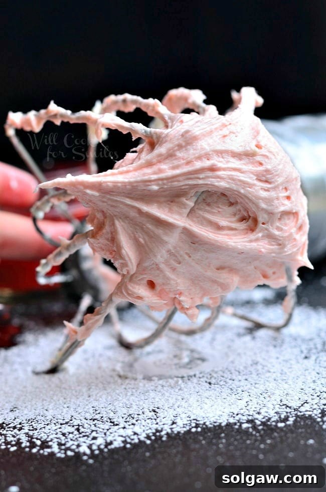 Close-up of smooth and creamy Strawberry Buttercream Frosting in a mixer bowl.