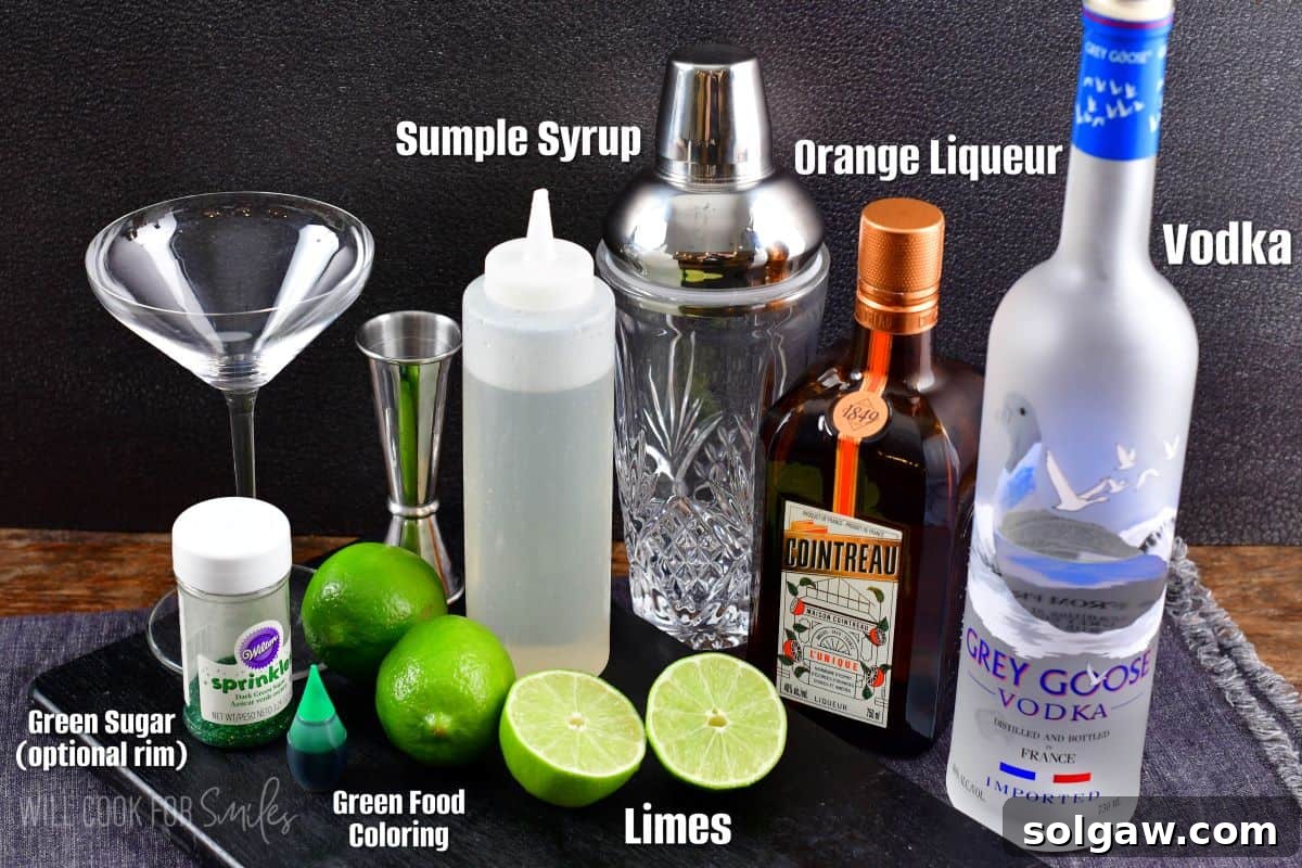 A collection of labeled ingredients for a lime martini, including bottles of vodka and orange liqueur, and fresh limes, arranged on a black board against a gray tablecloth.