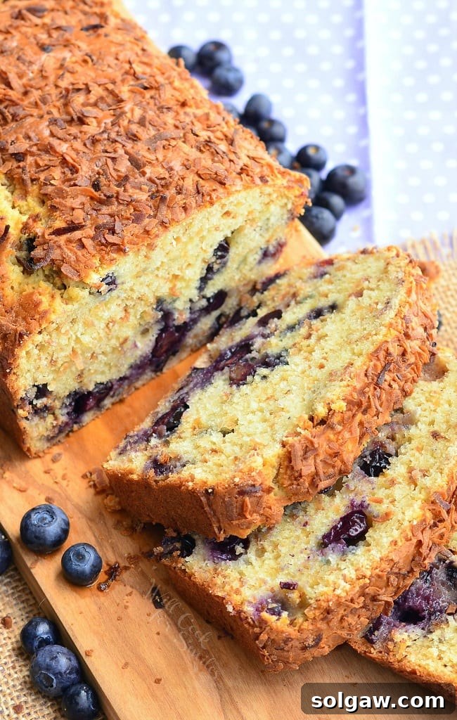 Toasted Coconut Blueberry Bread sliced on a cutting board, ready to be served