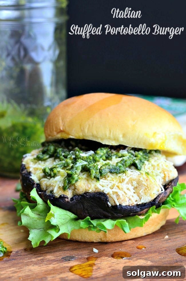 Delicious Italian Stuffed Portobello Burger on a bun with fresh arugula and a dollop of pesto.