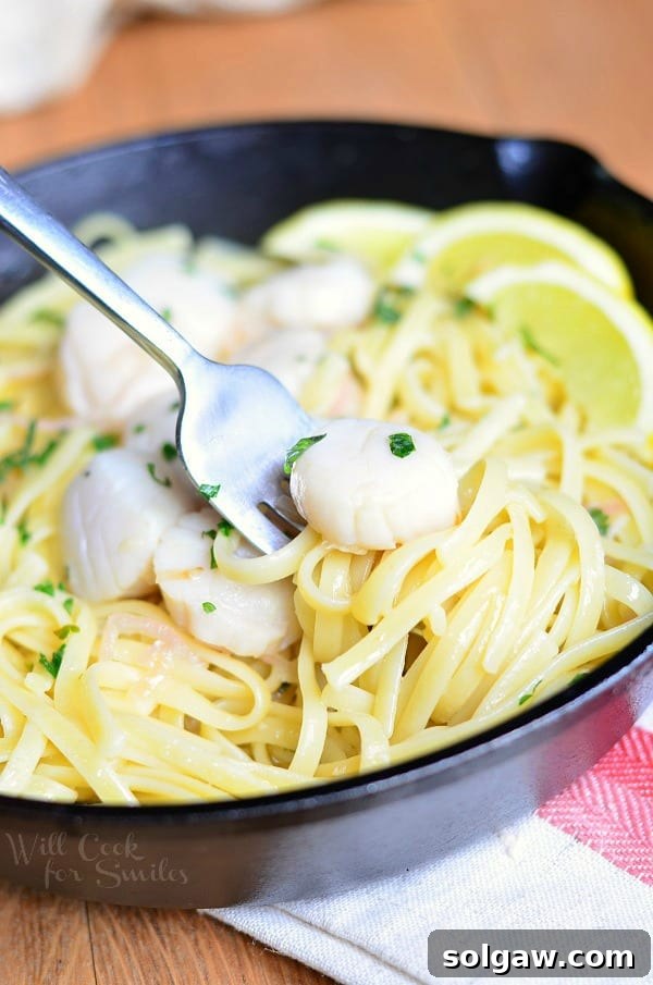 Scallop Scampi on a cast iron pan with a fork grabbing some out