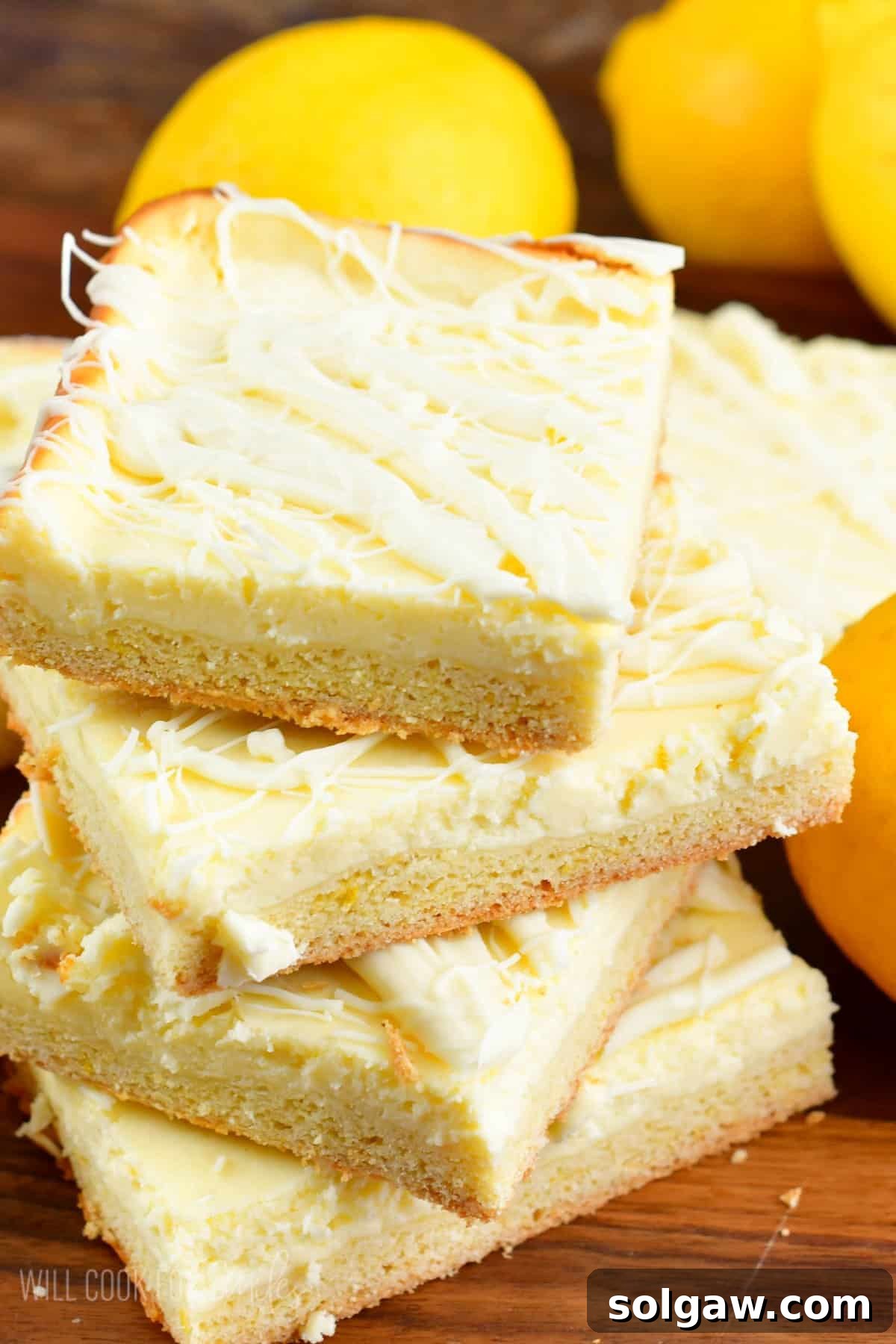 Perfectly cut and stacked lemon cheesecake cookie bars, showcasing their golden base and creamy lemon layer, ready to be served.
