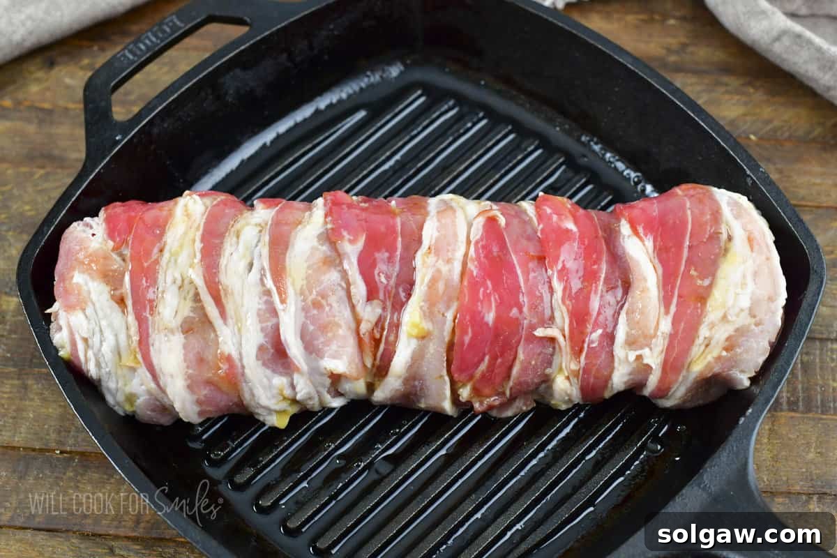 Bacon Wrapped Pork Perfection 8 Bacon wrapped pork tenderloin coated with honey, ready for roasting in the oven.