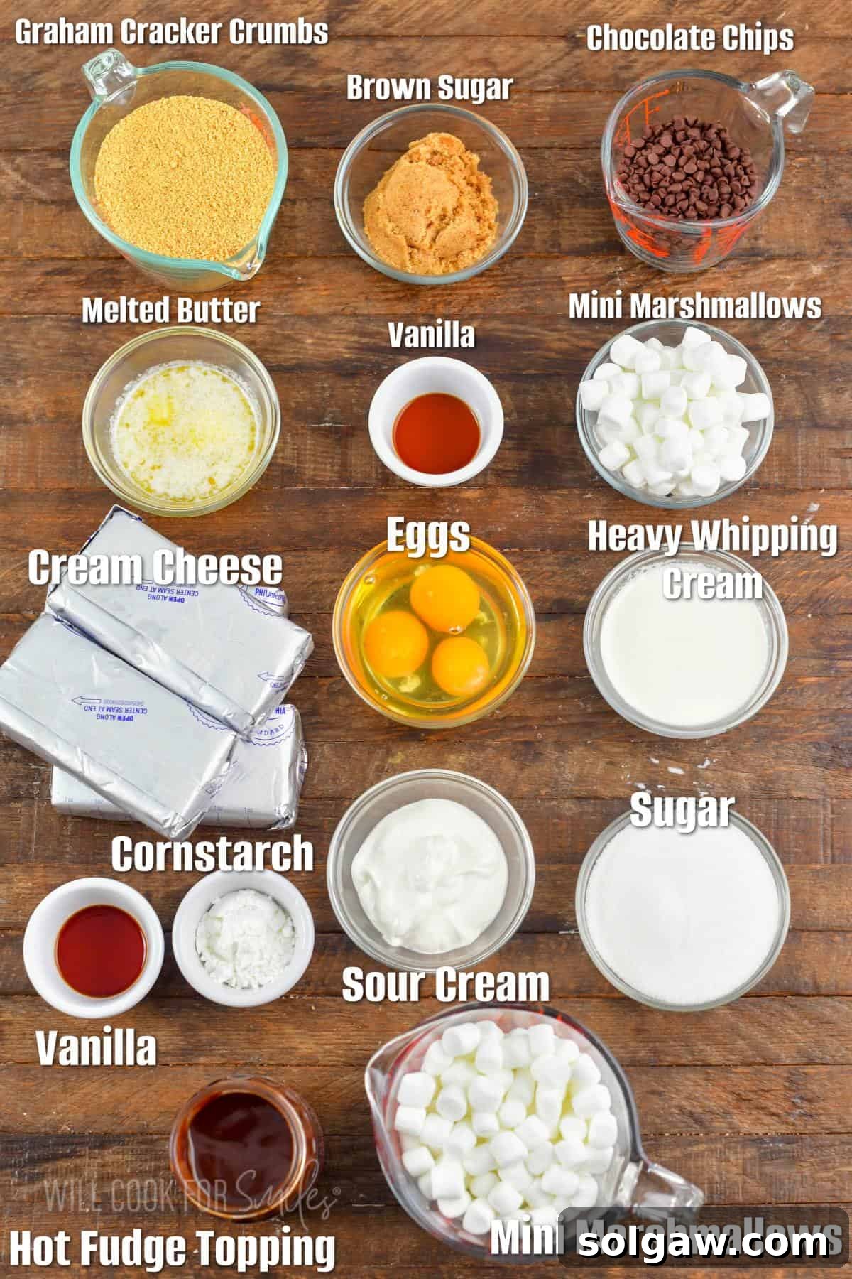 Labeled ingredients laid out on a wooden board, ready for making S'mores Cheesecake.